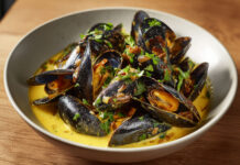 Mouclade charentaise aux moules, crème, vin blanc et curry Bol de moules de bouchot nappées de sauce crémeuse au curry et au vin blanc, typique de la mouclade charentaise.
