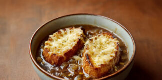 Bol de soupe à l’oignon gratinée avec tranches de pain dorées et fromage fondu – une recette française traditionnelle et réconfortante.