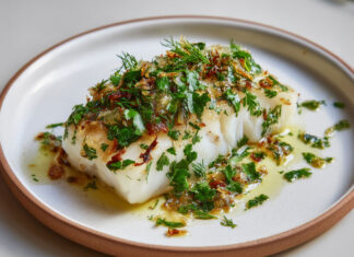 Dos de cabillaud cuit au four, nappé de citron confit haché et d’herbes fraîches, dans une sauce légère à l’huile d’olive.