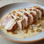 Tranches de filet mignon de porc nappées d’une sauce crémeuse au reblochon fondant, servies avec des oignons confits.