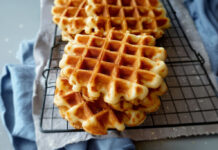Gaufres de Bruxelles maison dorées et croustillantes, empilées sur une grille à pâtisserie, prêtes à être dégustées.