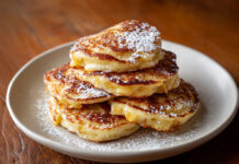 Crêpes aux pommes express et ultra gourmandes Petites crêpes aux pommes dorées servies chaudes avec sucre glace sur une assiette rustique.